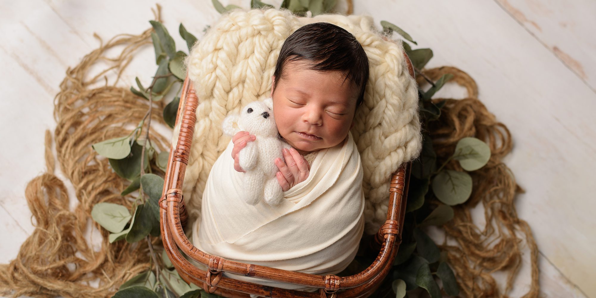 Newborn baby boy in a basket posed newborn photography in Oakville