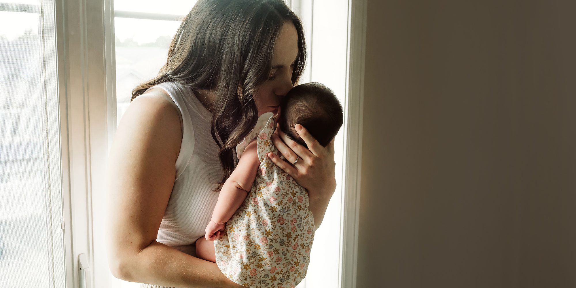A new mother holding her newborn baby at her lifestyle photo session